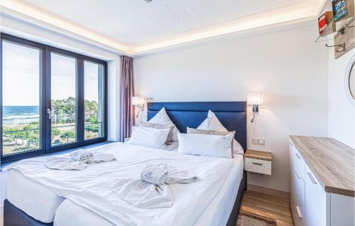 una camera da letto con un grande letto bianco con una grande finestra di Sunny a Binz