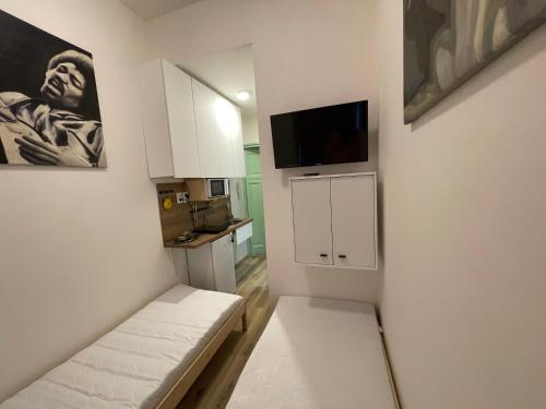 ein kleines Wohnzimmer mit einem Sofa und einem TV in der Unterkunft Red&Black Apartment City centr, Na Hradbách 118 in Ostrava