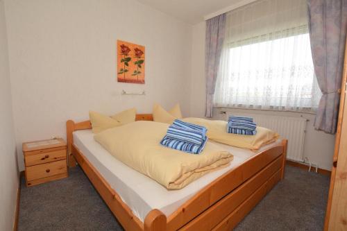ein Schlafzimmer mit einem Bett mit zwei Kissen darauf in der Unterkunft Haus Bünzow 1 in Borkum