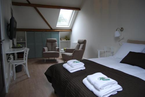 um quarto com uma cama com toalhas em Bed & Breakfast Langlaar em Nuenen