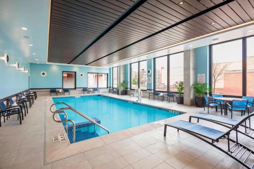uma piscina com cadeiras e mesas num edifício em SpringHill Suites Madison em Madison