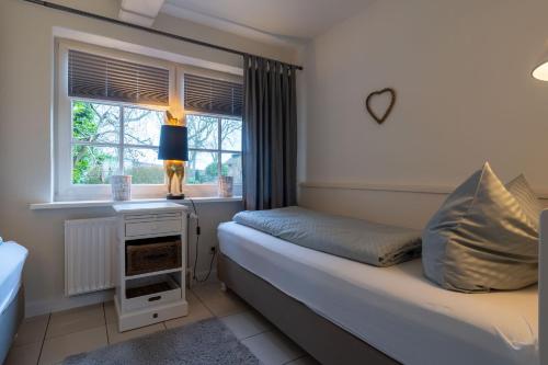 a bedroom with a bed and a window at Hus op de Dun in Sankt Peter-Ording