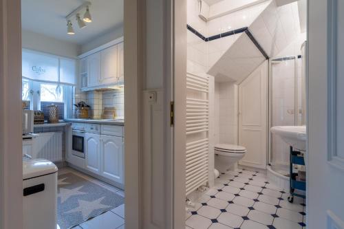 a white bathroom with a toilet and a sink at Hus op de Dun in Sankt Peter-Ording