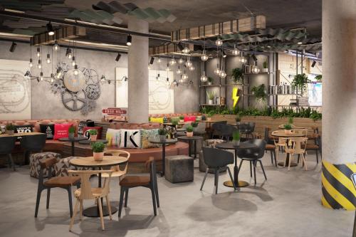 a restaurant with tables and chairs in a room at Moxy Cologne Muelheim in Cologne