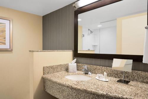 La salle de bains est pourvue d'un lavabo et d'un miroir. dans l'établissement Courtyard by Marriott Newark Downtown, à Newark