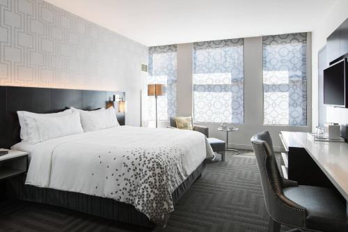 a hotel room with a large bed and a desk at Renaissance Cincinnati Downtown Hotel in Cincinnati