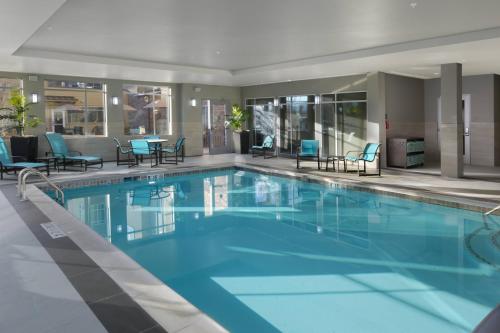 a large swimming pool with blue chairs and tables at Residence Inn by Marriott Denver Southwest/Littleton in Littleton