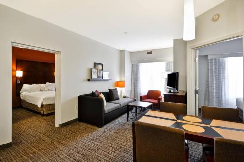 a hotel room with a bed and a living room at Residence Inn by Marriott Gulfport-Biloxi Airport in Gulfport