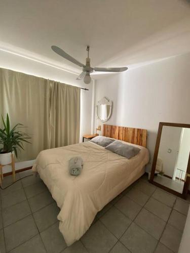 1 dormitorio con 1 cama con ventilador y espejo en Hermoso apartamento en Palermo - La Rural en Buenos Aires