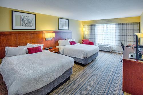 um quarto de hotel com duas camas e uma televisão em Courtyard Fargo Moorhead, MN em Moorhead