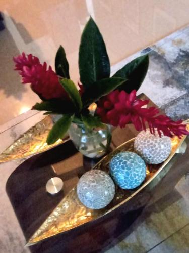 a table with a vase with rocks and flowers in it at Villa Maison de Soleil in Florence Hall