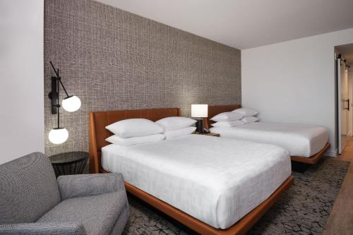 a hotel room with two beds and a couch at Sheraton Flowood The Refuge Hotel & Conference Center in Flowood
