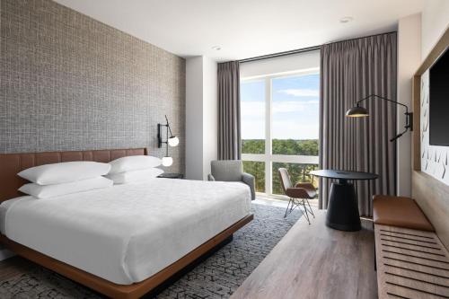 a hotel room with a bed and a large window at Sheraton Flowood The Refuge Hotel & Conference Center in Flowood
