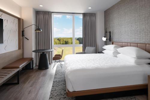 a hotel room with a large bed and a window at Sheraton Flowood The Refuge Hotel & Conference Center in Flowood