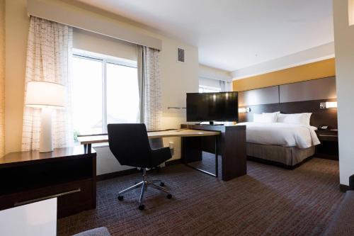 a hotel room with a bed and a desk with a computer at Residence Inn by Marriott Oklahoma City North/Quail Springs in Oklahoma City