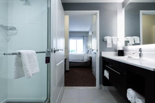 uma casa de banho com um chuveiro, um lavatório e um espelho. em Residence Inn by Marriott Oklahoma City North/Quail Springs em Oklahoma City