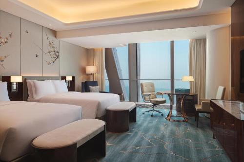 a hotel room with two beds and a desk at Na Lotus Hotel, a Luxury Collection Hotel, Nanning in Nanning