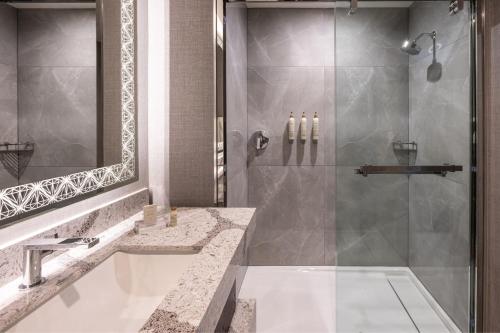y baño con ducha y lavamanos. en Renaissance Oklahoma City Downtown Bricktown Hotel, en Oklahoma City
