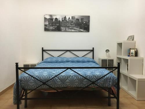 ein Bett in einem Schlafzimmer mit einem Bild an der Wand in der Unterkunft Il mare a 100 M da casa con ampio giardino in Torregrotta