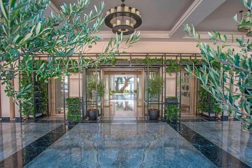モライティカにあるDomes Miramare, a Luxury Collection Resort, Corfu - Adults Onlyの植物が壁に飾られたロビーと天井