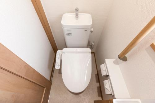 a bathroom with a white toilet with a sink at Y's沖縄リゾートベースNo.3 in Onna