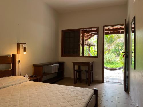um quarto com uma cama e uma porta de vidro deslizante em Itamambuca Suites em Ubatuba