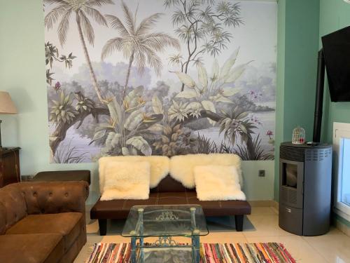 a living room with a couch and a palm tree mural at Nacaren Cullera in Cullera