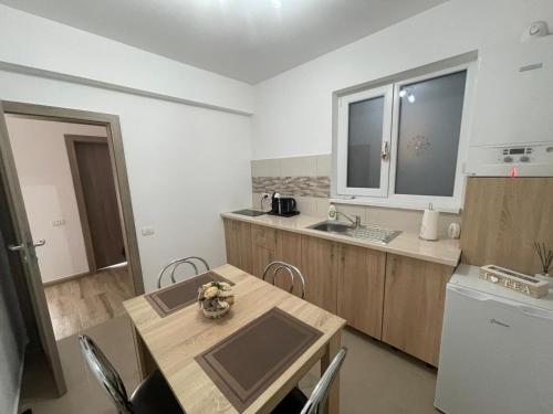 a kitchen with a wooden table and a sink at Bonte Residence str Daliei nr 3 Giroc in Giroc