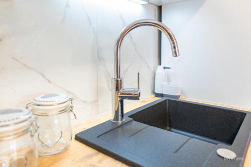 um lavatório de cozinha com uma torneira no balcão em Apartament na deptaku, MyWeek em Polanica-Zdrój