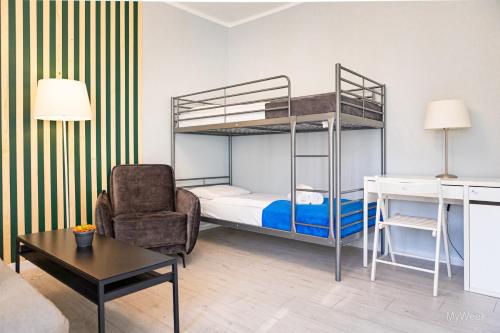 a living room with a bunk bed and a chair at Apartament na deptaku, MyWeek in Polanica-Zdrój