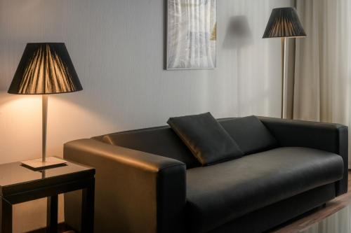 a living room with a couch and a lamp at AC Hotel by Marriott Madrid Airport in Coslada