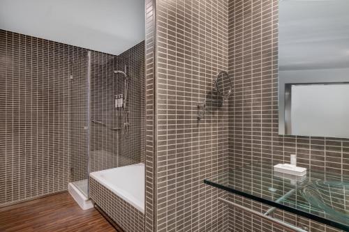 a bathroom with a shower and a toilet and a sink at AC Hotel Coslada Aeropuerto by Marriott in Coslada