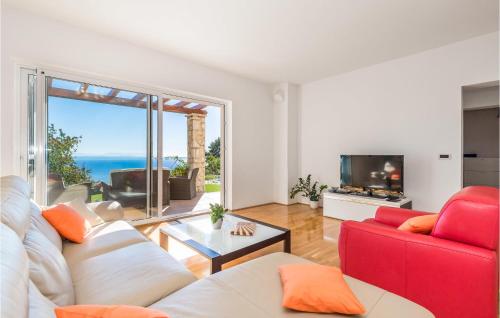 a living room with a red couch and a tv at Nice Home In Lovran With Sauna in Lovran