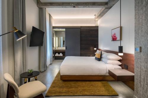 a hotel room with a bed and a chair at The Hi-Lo, Autograph Collection in Portland