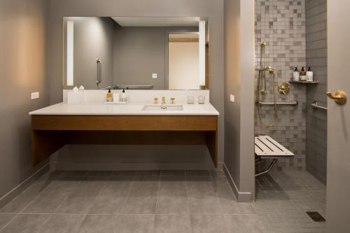 a bathroom with a sink and a mirror and a shower at The Hi-Lo, Autograph Collection in Portland
