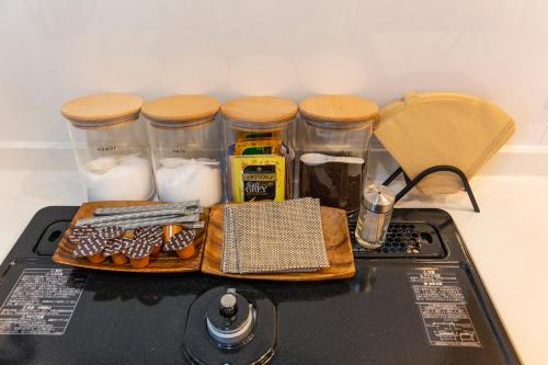 a table with jars of food on top of a stove at Y's沖縄リゾートベースNo.3 in Onna