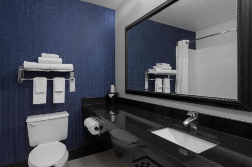 a bathroom with a toilet and a sink and a mirror at Fairfield Inn Kennewick in Kennewick