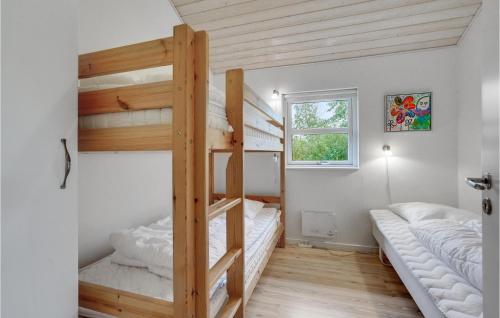 BrovstにあるAmazing Home In Brovst With Saunaのベッドルーム1室(二段ベッド2台、窓付)が備わります。