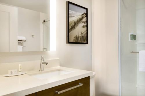 a bathroom with a sink and a mirror at TownePlace Suites by Marriott Outer Banks Kill Devil Hills in Kill Devil Hills