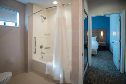 La salle de bains est pourvue d'une baignoire, d'une douche et de toilettes. dans l'établissement Residence Inn by Marriott Pensacola Airport/Medical Center, à Pensacola