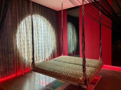 a swinging bed in a room with red walls at Ouwei Motel in Tainan