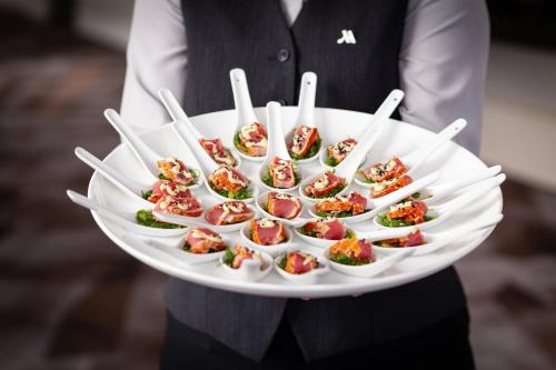 a person holding a plate of food with chopsticks at Tampa Airport Marriott in Tampa