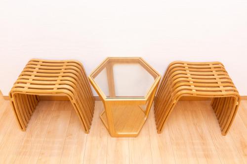 two wicker chairs sitting on a wooden floor at Y's沖縄リゾートベースNo.3 in Onna
