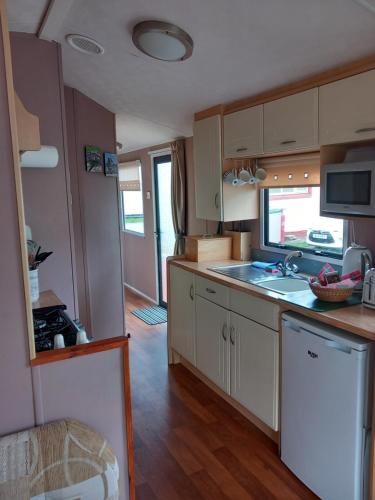 una cucina con lavandino e piano di lavoro di Melody Brooks Caravan Park a Portknockie