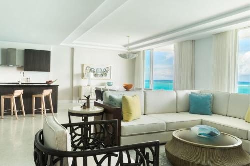 a living room with a white couch and a kitchen at The Ritz-Carlton Residences, Turks & Caicos in Providenciales