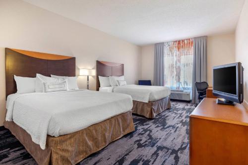 a hotel room with two beds and a flat screen tv at Fairfield Inn & Suites by Marriott Rockford in Rockford