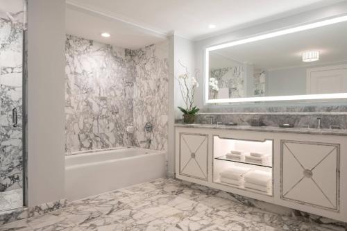 a bathroom with a tub and a sink and a mirror at The Ritz-Carlton, New Orleans in New Orleans