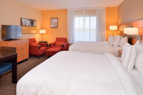 a hotel room with two beds and a flat screen tv at TownePlace Suites by Marriott Huntsville West/Redstone Gateway in Huntsville