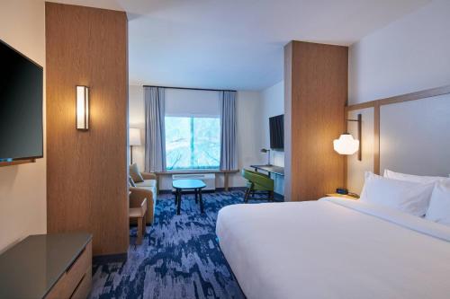 a hotel room with a large bed and a desk at Fairfield Inn & Suites by Marriott Louisville Jeffersonville in Jeffersonville