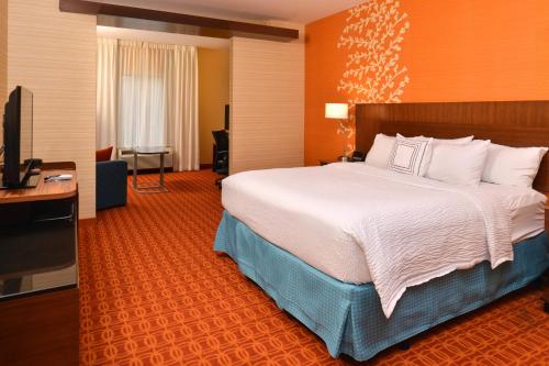 a hotel room with a bed and a flat screen tv at Fairfield Inn and Suites by Marriott Calhoun in Calhoun